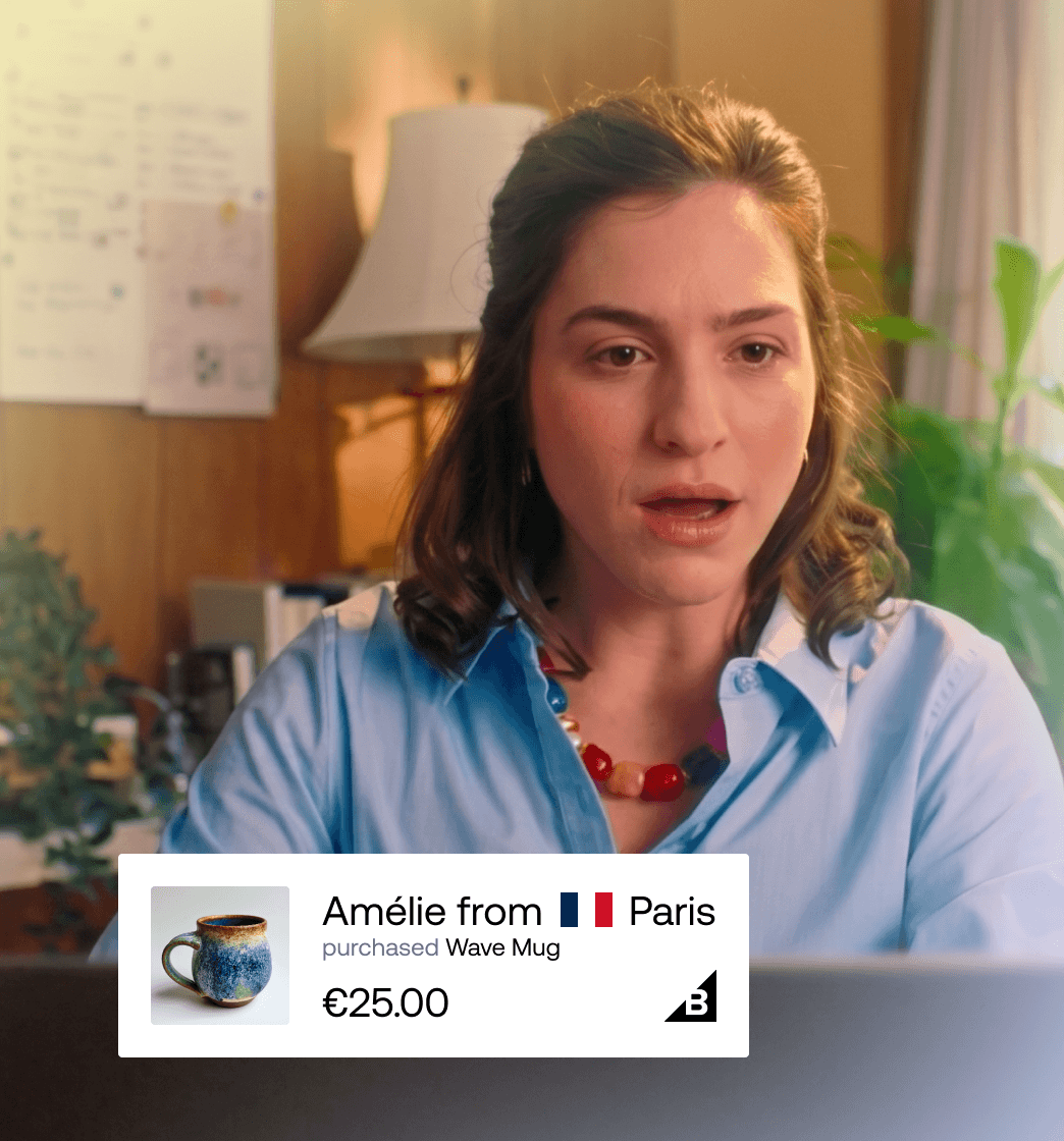 Frau schaut auf einen Bildschirm mit Live-Social-Proof-Badge, der zeigt, dass Amélie aus Paris eine Wave Mug für 25 € gekauft hat.