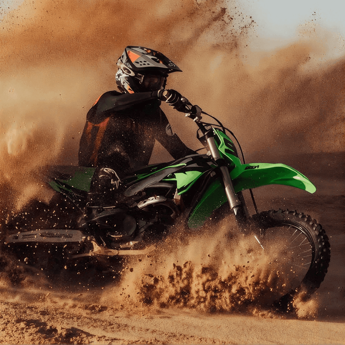 Motocross-Fahrer wirbelt in einer scharfen Kurve Sand und Staub mit einem grünen Offroad-Dirt-Bike auf.